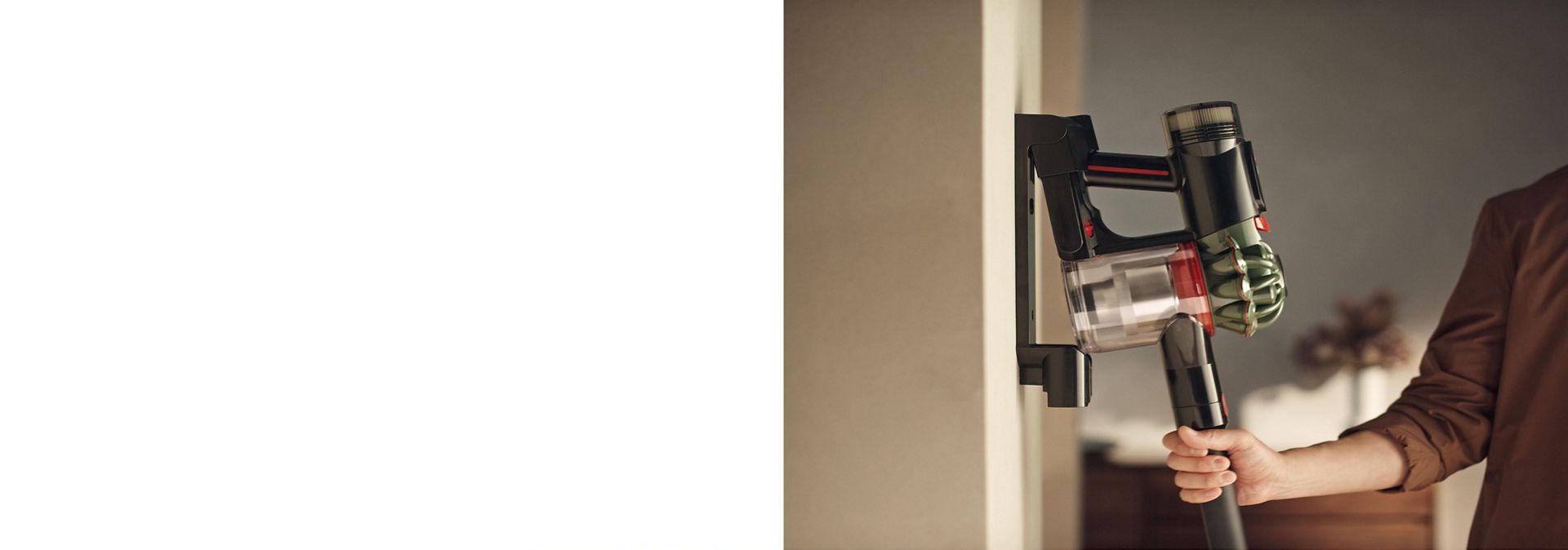 The Dyson V8 Cyclone vacuum is returned to its charging dock.