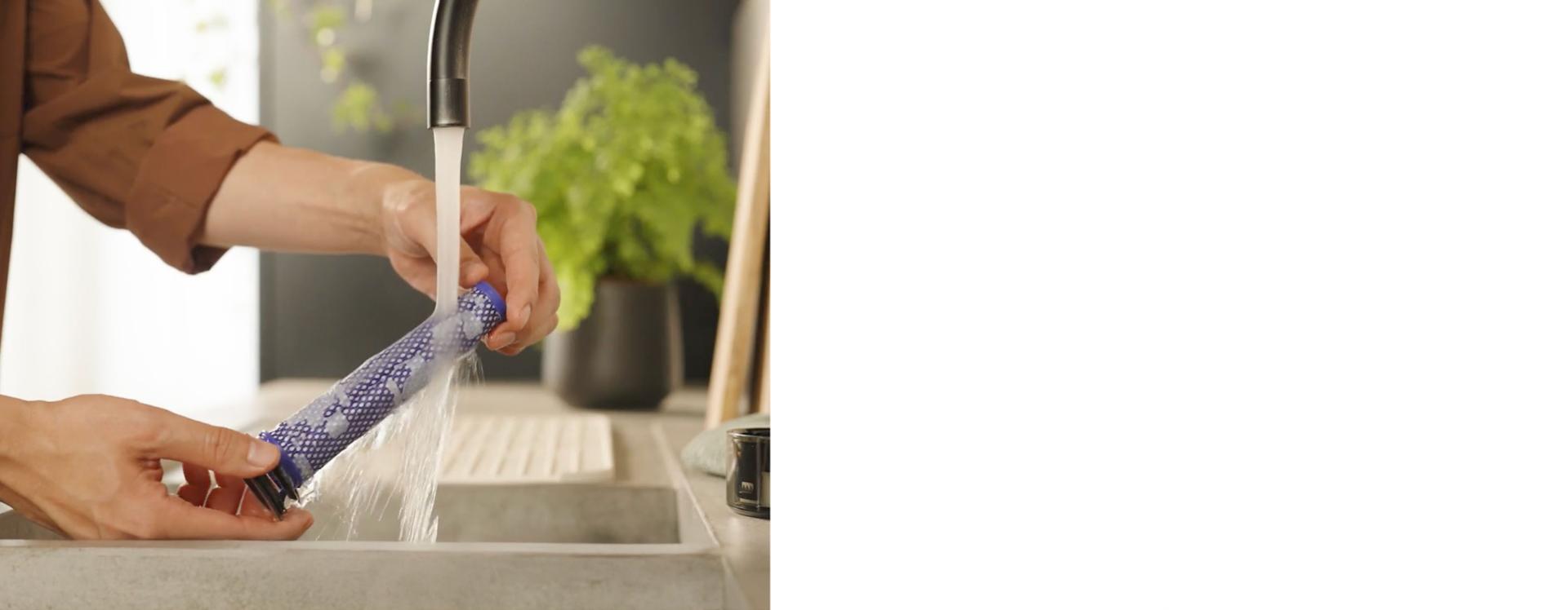 The Pre-filter of the Dyson V8 Cyclone vacuum is cleaned under running water.