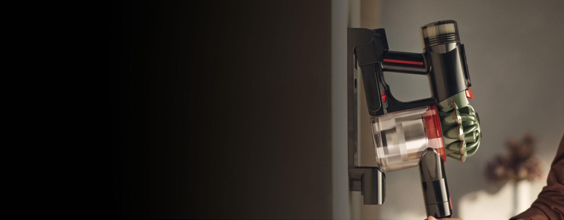 The Dyson V8 Cyclone vacuum is returned to its charging dock.