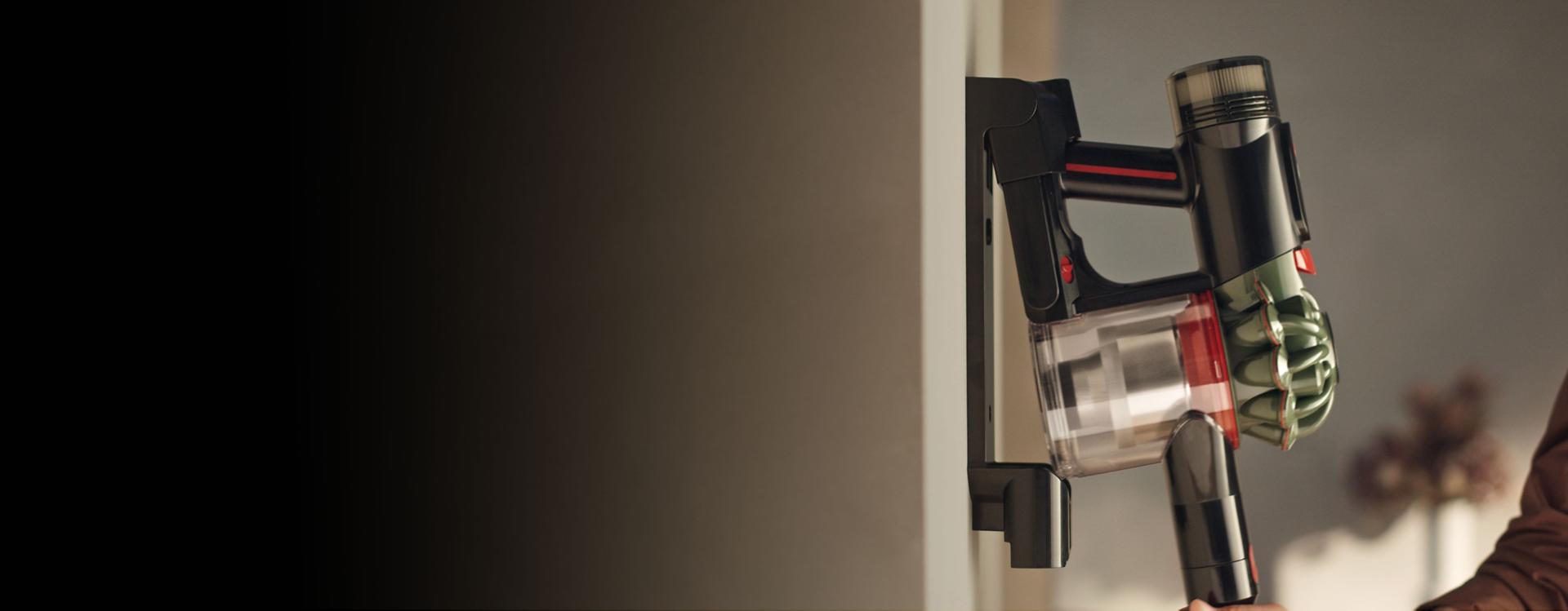 Dulkių siurblys „Dyson V8 Cyclone“ grąžinamas į įkrovimo stotelę.