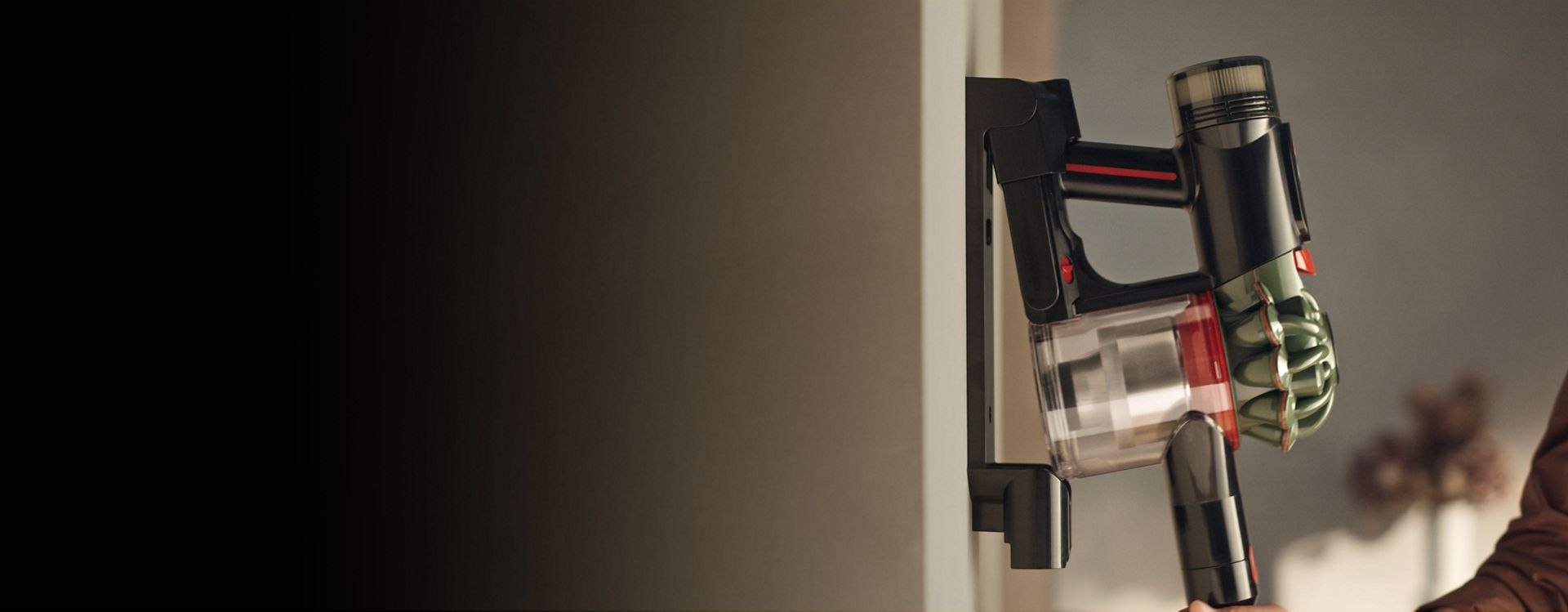 The Dyson V8 Cyclone vacuum is returned to its charging dock.