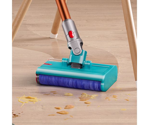 Końcówka do czyszczenia na mokro Dyson Submarine w trakcie sprzątania między wysokimi nogami krzeseł.