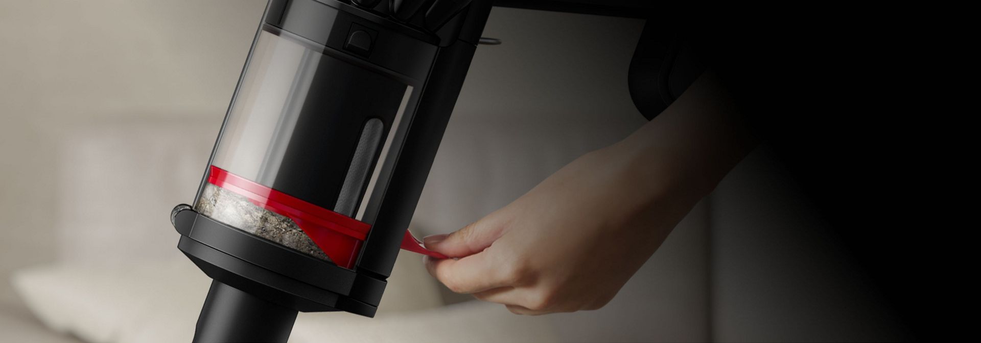 شخص يقوم بضغط الأتربة داخل حاوية مكنسة Dyson Piston Animal.