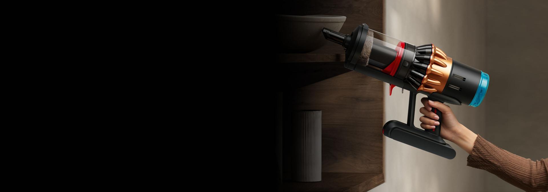 The built-in crevice tool being used to clean around a table.