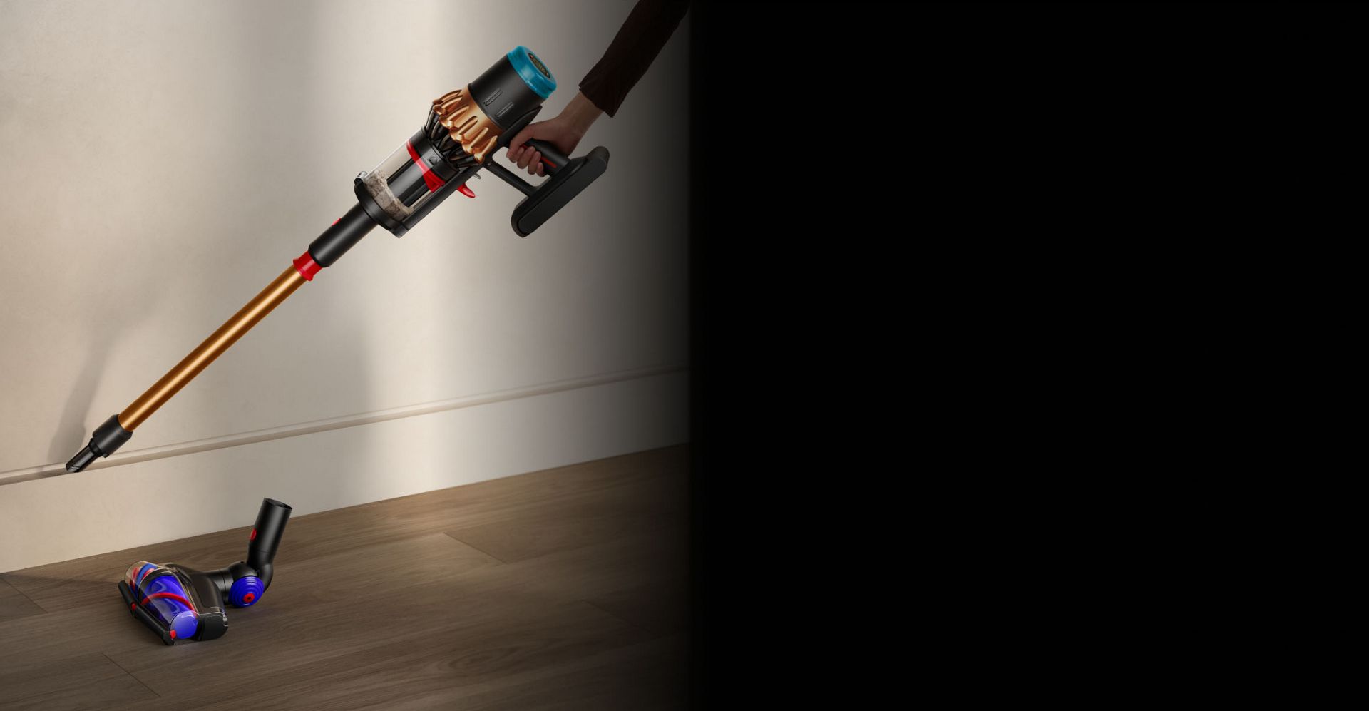 أداة العصا الخاصة بمكنسة Dyson Piston Animal بينما تُستخدَم لتنظيف حافة لوح إزار حائط.