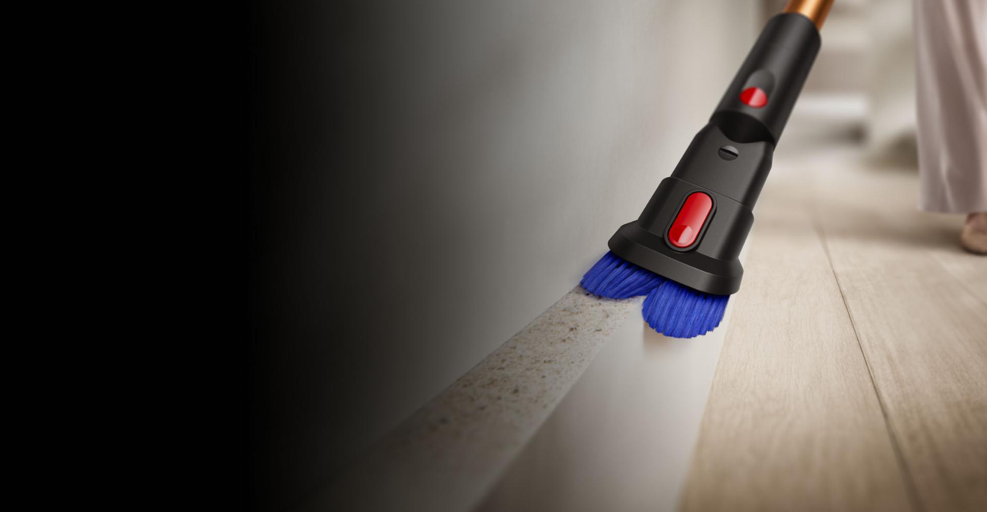 Tolmuimeja Dyson Piston Animal kombitarvikuga puhastatakse laua ümbrust.