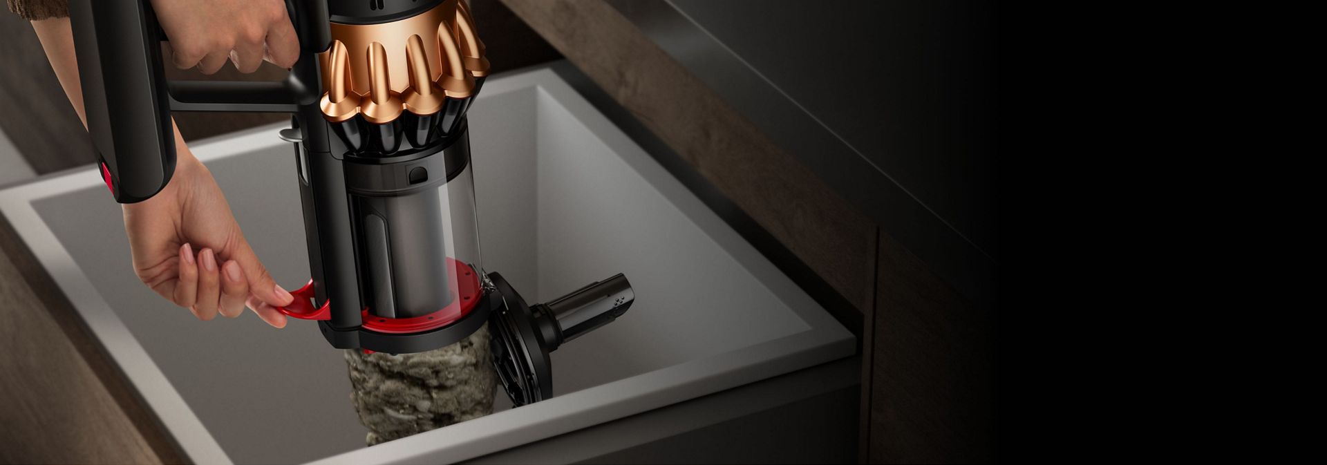 شخصٌ يُفرغ مع التنظيف بالمسح للأتربة الموجودة في حاوية مكنسة Dyson V16 Piston Animal، باستخدام الذراع الموجود على جانبها.