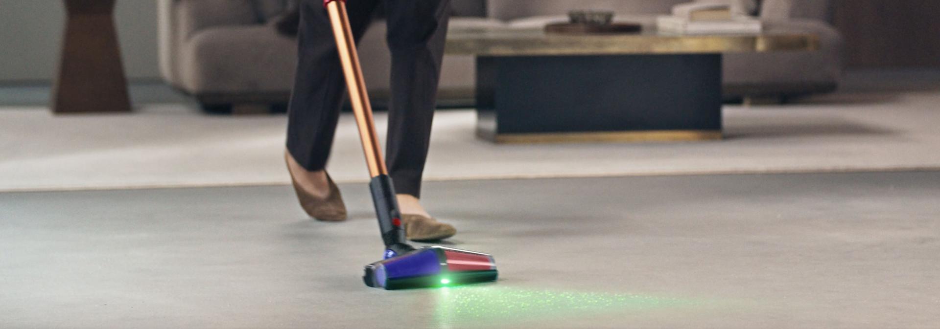A person using the Dyson DS60 Piston Animal cordless vacuum with the All Floor Cones Sense cleaner head.