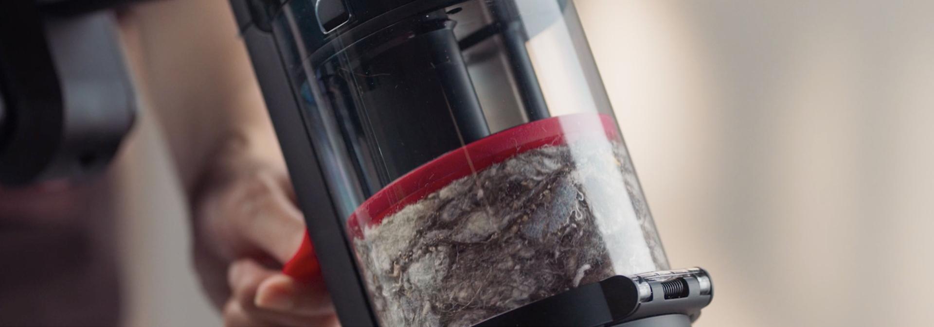 صورة مُقرَّبة لحاوية المكنسة، مليئة بالمخلفات.