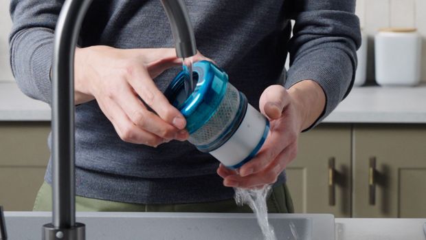 The filter of the Dyson DS60 Piston Animal vacuum is cleaned under running water.