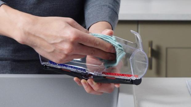 The plastic cover of the All Floor Cones Sense cleaner head is cleaned with a dampened cloth.