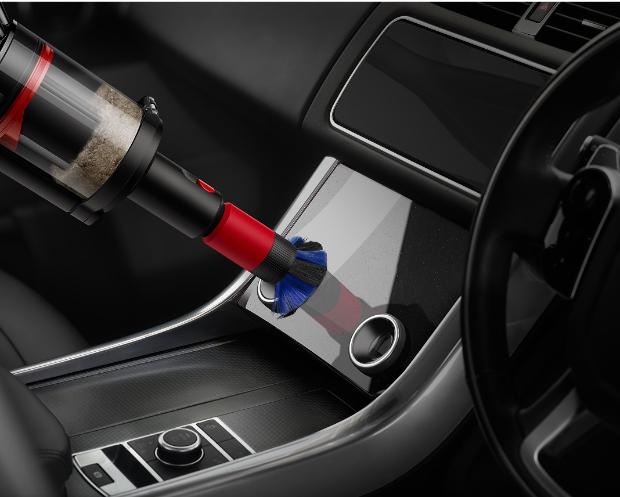The Scratch-free dusting brush is used to clean a screen in a car.