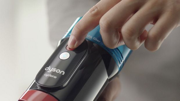 The mode select button is pressed on the Dyson V10 vacuum.