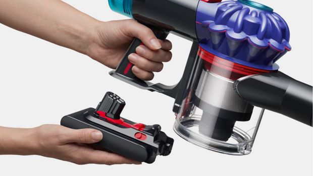A battery is clicked into the handle of the Dyson V10 vacuum.