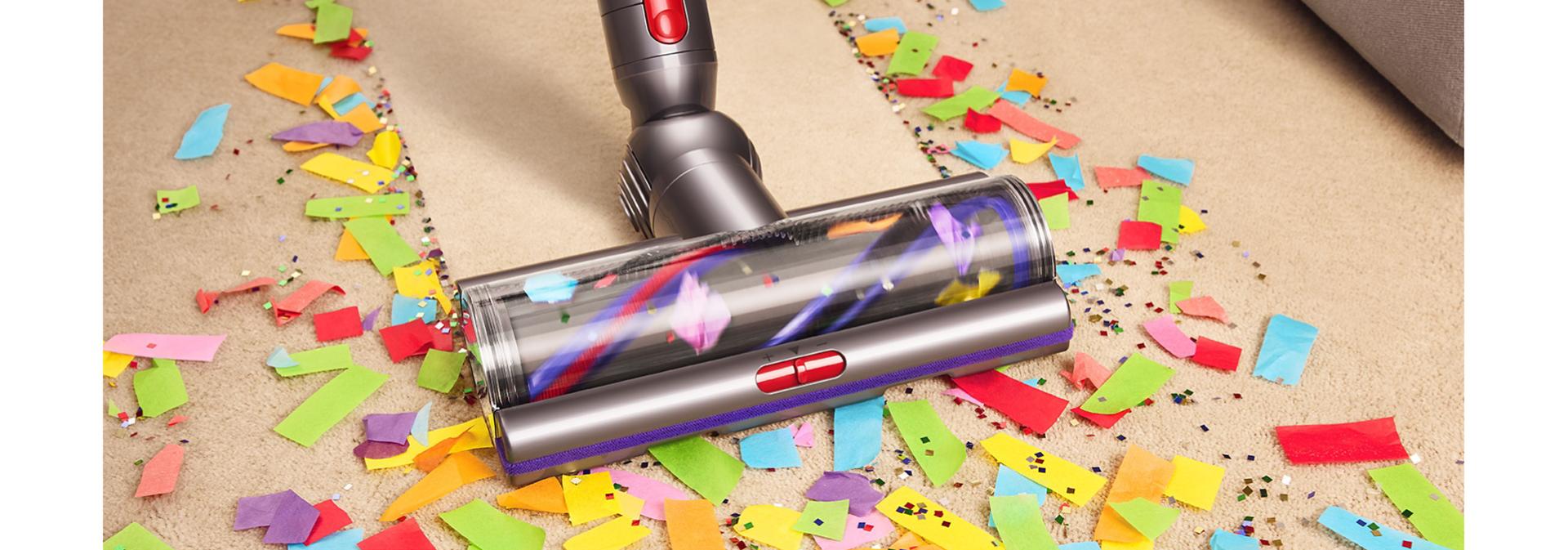 Vysávač Dyson V15 Detect sa používa s podlahovou hubicou Digital Motorbar na čistenie nečistôt z koberca.