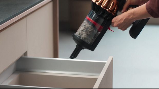 Dyson CleanCompaktor bin is emptied into household waste.