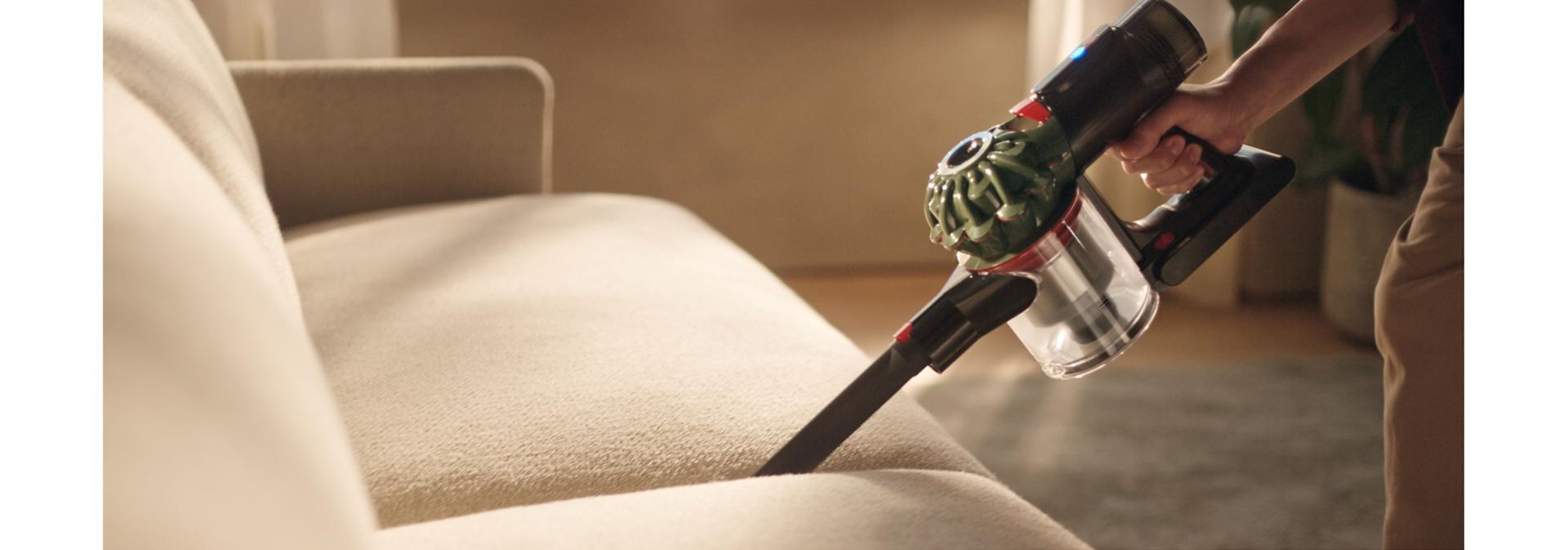 Dyson V8 Cyclone vacuum used to clean between cushions.
