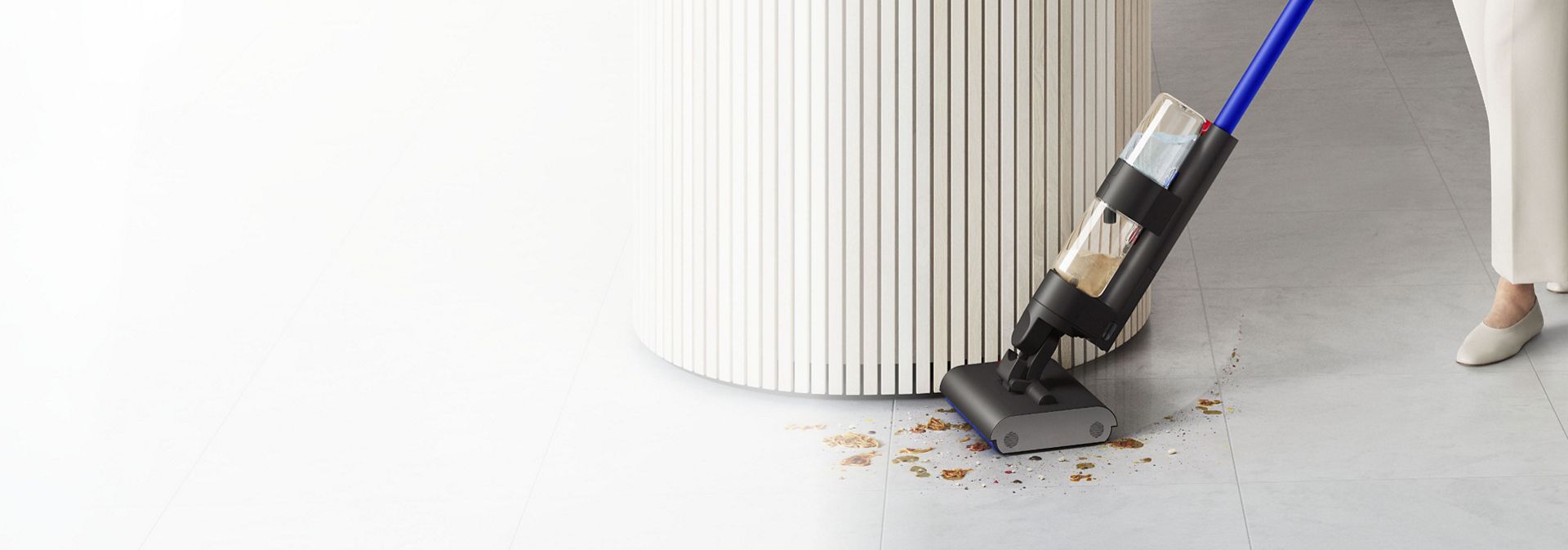 Wysokoobrotowy mop elektryczny Dyson WashG1 w trakcie czyszczenia podłogi wokół wyspy kuchennej.