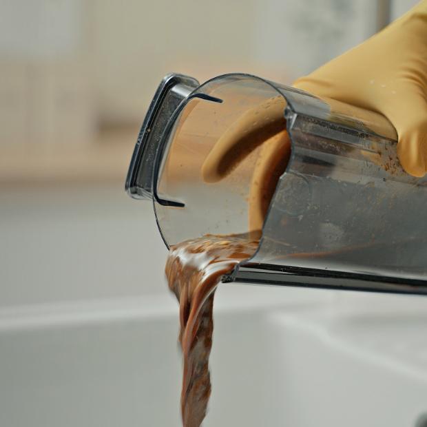 Dirty water being poured out of a wet cleaner bin.