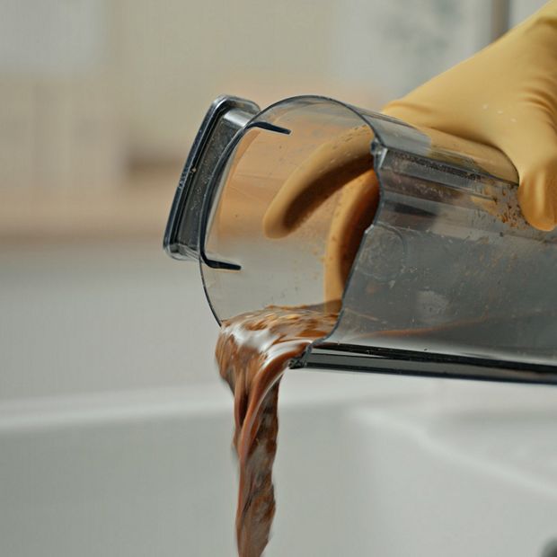 Dirty water being poured out of a wet cleaner bin.
