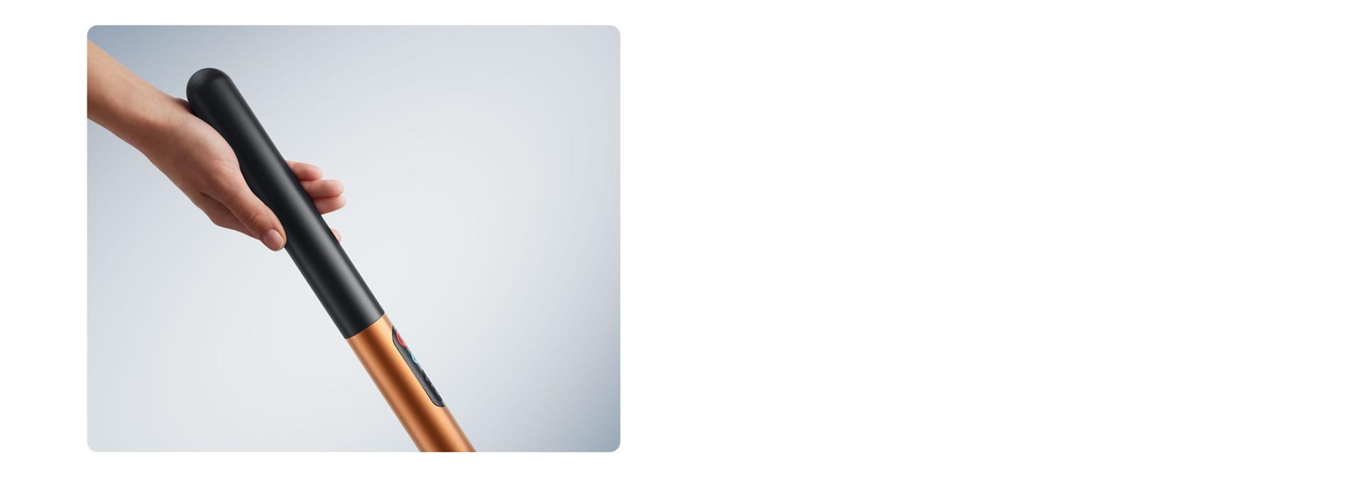 Egy kéz fogja a Dyson PencilWash keménypadló-tisztító akkumulátoros fogantyúját.