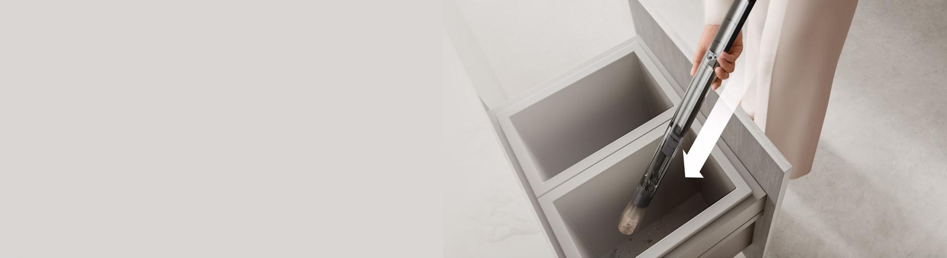 Sběrná nádoba se stlačováním vysavače Dyson PencilVac je vyprazdňována hluboko do odpadkového koše.