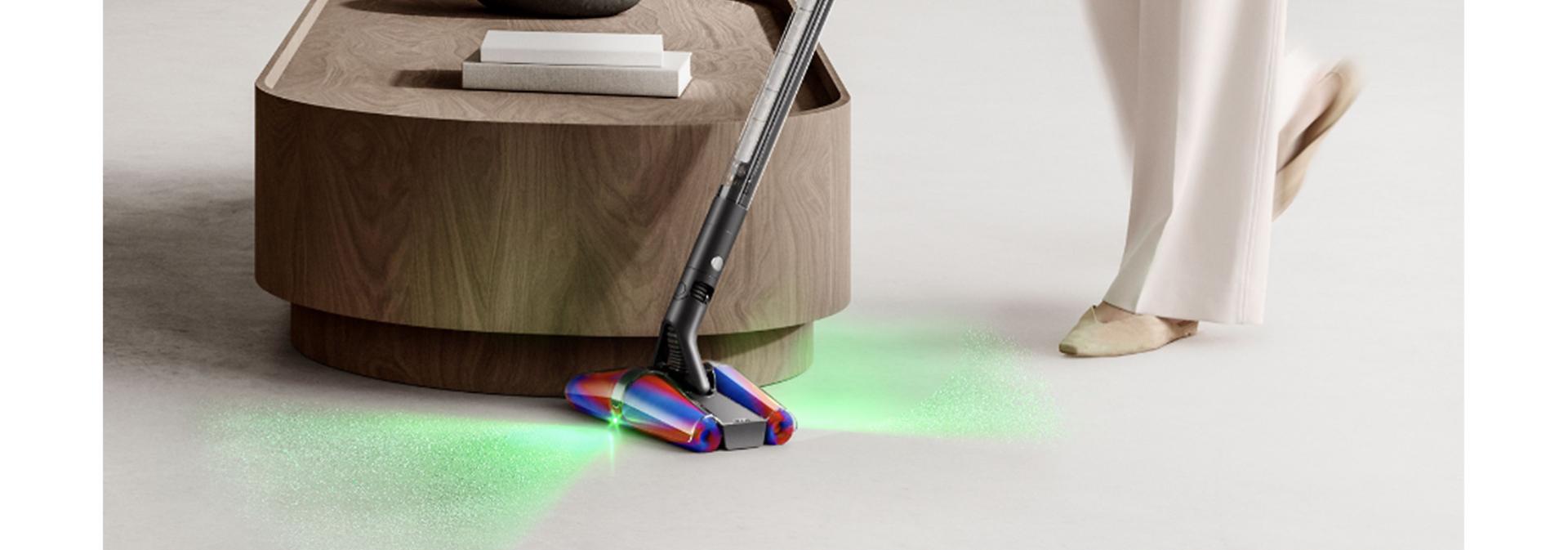 Dyson PencilVac cleaner used to clean around a coffee table in a home.