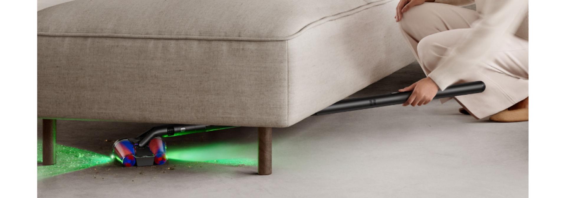 Dyson PencilVac cleaner used to clean underneath a sofa.