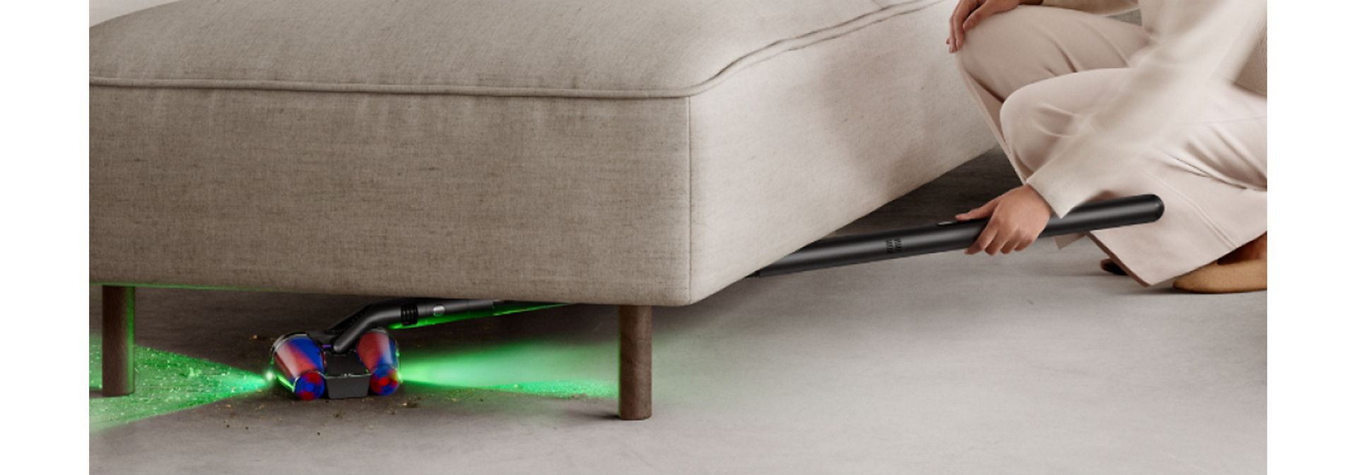 Dyson PencilVac cleaner used to clean underneath a sofa.
