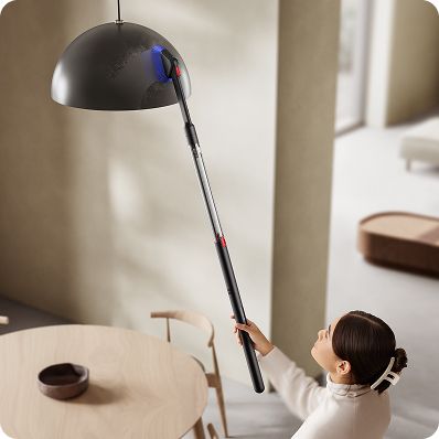 Dyson PencilVacクリーナーと回転式コンビクレビスツールを使って、天井に取り付けられた照明を掃除
