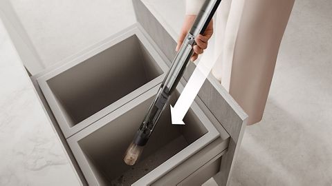 The Dyson PencilVac cleaner’s air-compression bin is emptied deep a household bin.