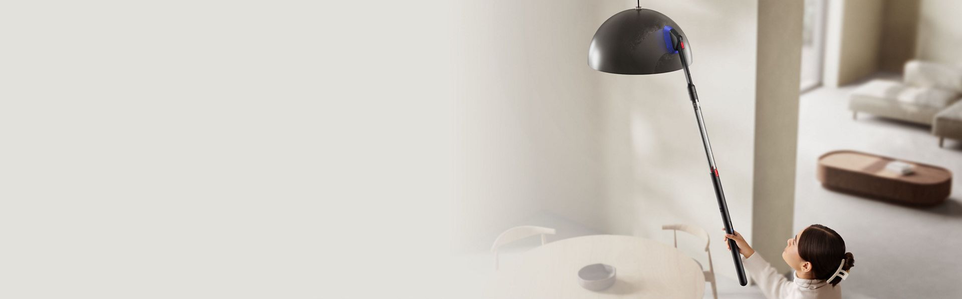 The Dyson PencilVac cleaner is used with the Rotating combi-crevice tool to clean a ceiling-mounted light.