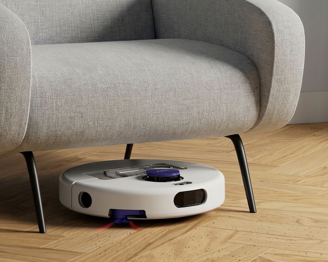 A Dyson R1 Nurovi or R2 Nurovi robot vacuum cleaner under a chair. A Dyson R1 Nurovi or R2 Nurovi robot vacuum cleaner under a chair.