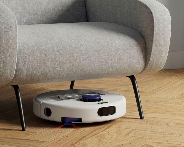 A Dyson R1 Nurovi or R2 Nurovi robot vacuum cleaner under a chair.