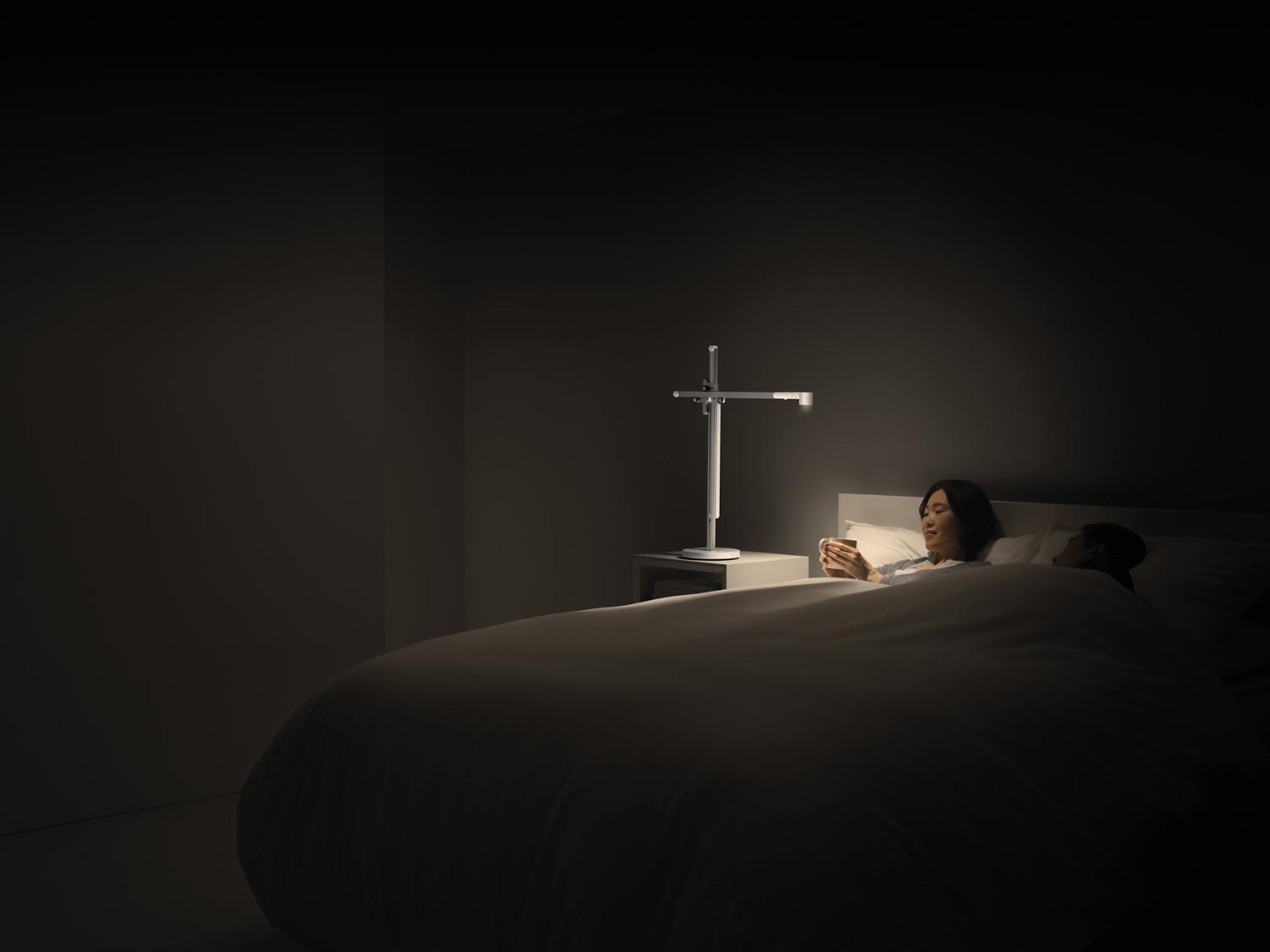 A woman drinks tea in bed in relaxing light