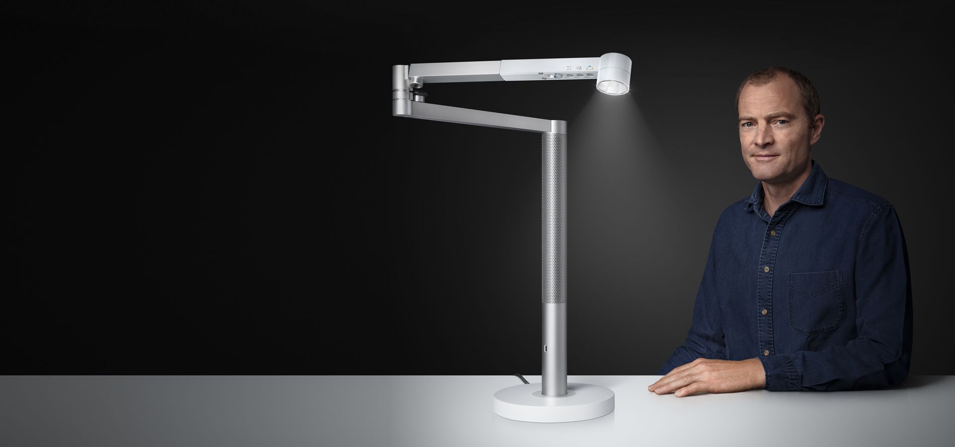 Jake Dyson sitzt neben einer Dyson Solarcycle Morph Leuchte