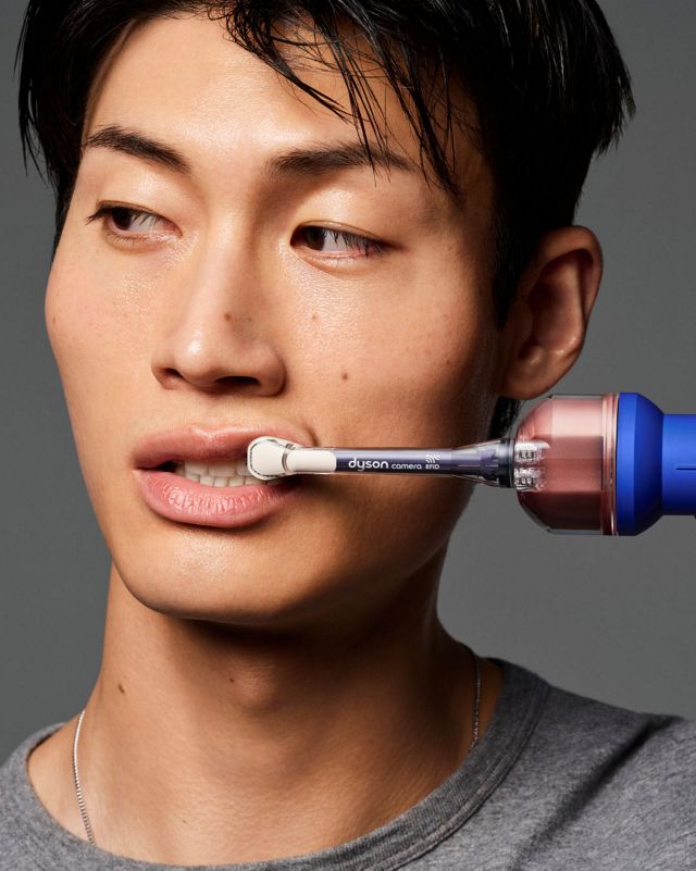 A person brushes their teeth using the Dyson CameraJet toothbrush.