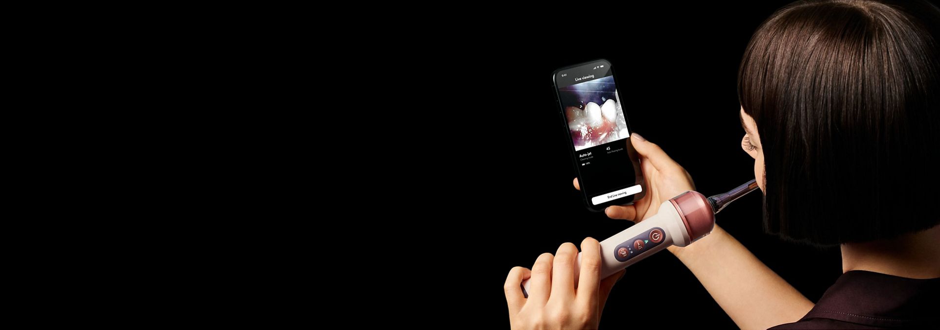 A person uses the MyDyson app and the Dyson CameraJet toothbrush.