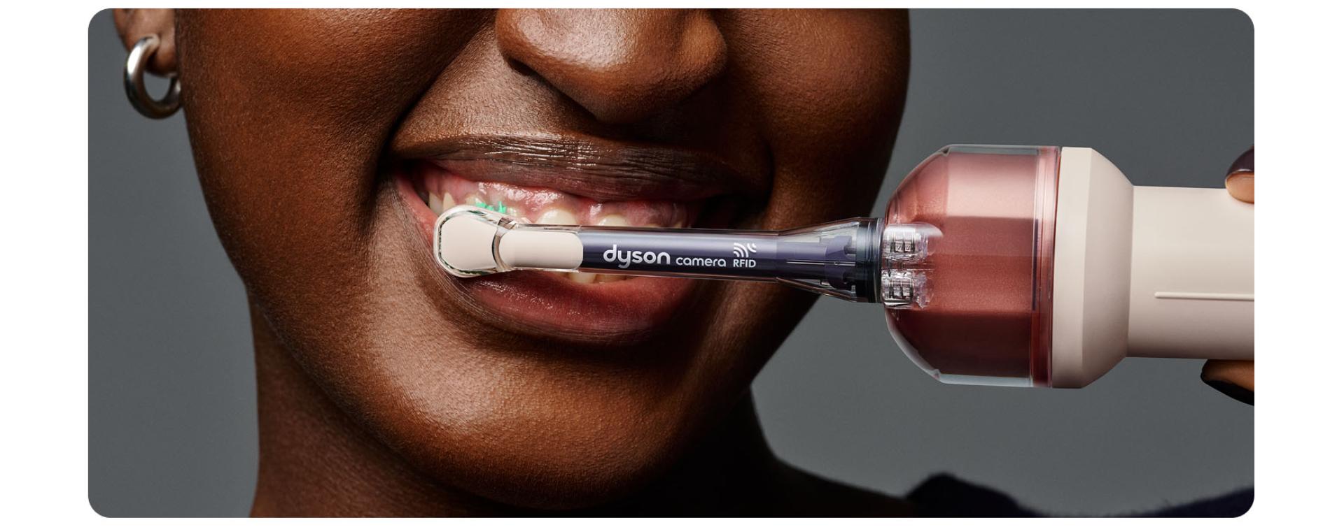 Person brushes their teeth using the Dyson CameraJet toothbrush.