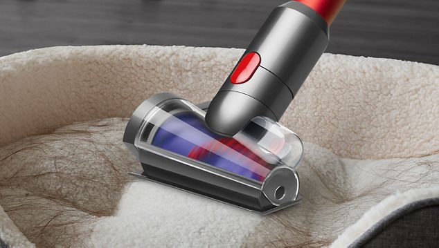 Dyson Outsize Staubsauger bei der Reinigung eines Autositzes im Handheld-Modus.