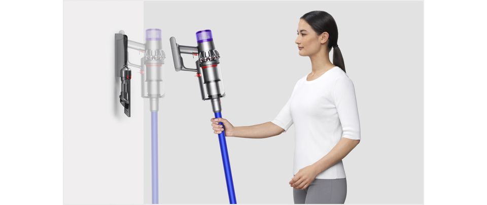  Frau setzt den Dyson V11™ Staubsauger in die Wandhalterung mit Ladefunktion ein
