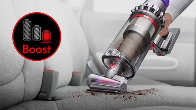Dyson Outsize Staubsauger im Handstaubsaugermodus mit Haardüse bei der Reinigung eines Autoinnenraums.