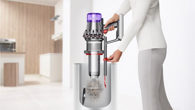 Frau entleert den Staubbehälter des Dyson Outsize Staubsaugers in den Mülleimer