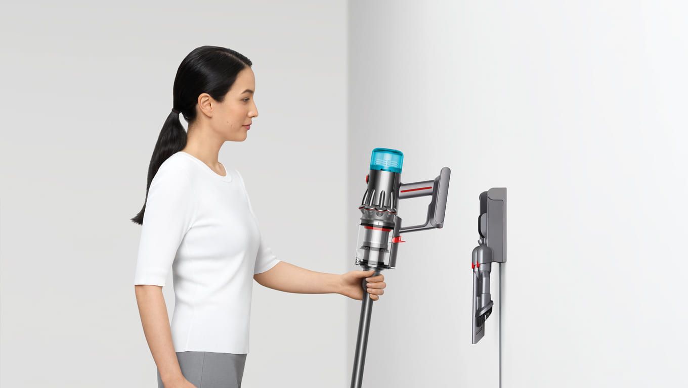 Frau hängt Dyson V12™ in Wandhalterung Dyson V12™ Wall Mount
