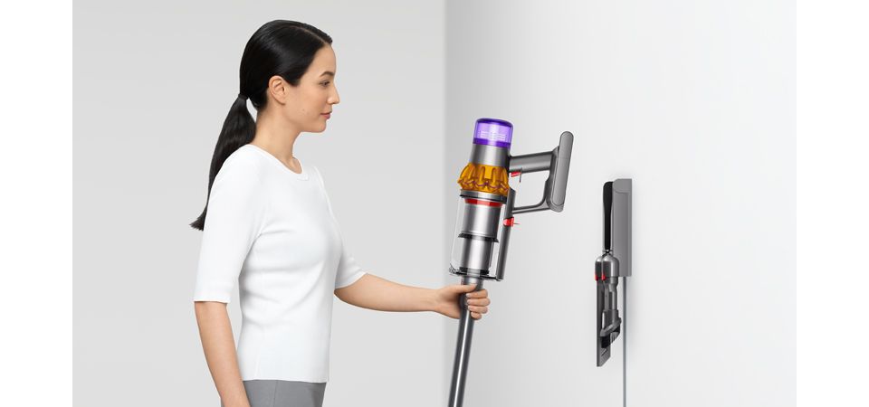 En kvinna placerar Dyson-dammsugaren i väggdockan