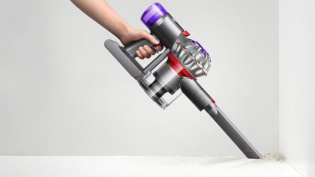 Ein Dyson Car+Boat wird mit der Fugendüse verwendet, um bis in die Ecke an einer Wand zu reinigen.