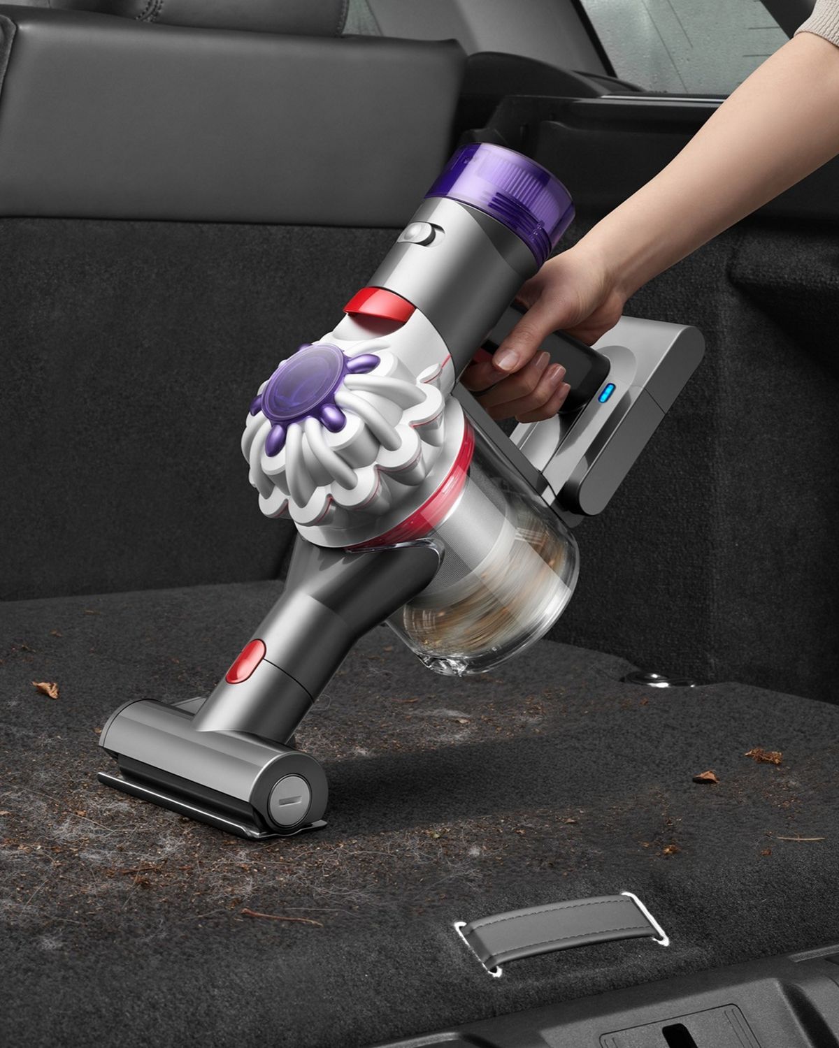 The Dyson Car+Boat handheld vacuum with the Mini motorised tool cleaning dirt, dust and hair from a car.