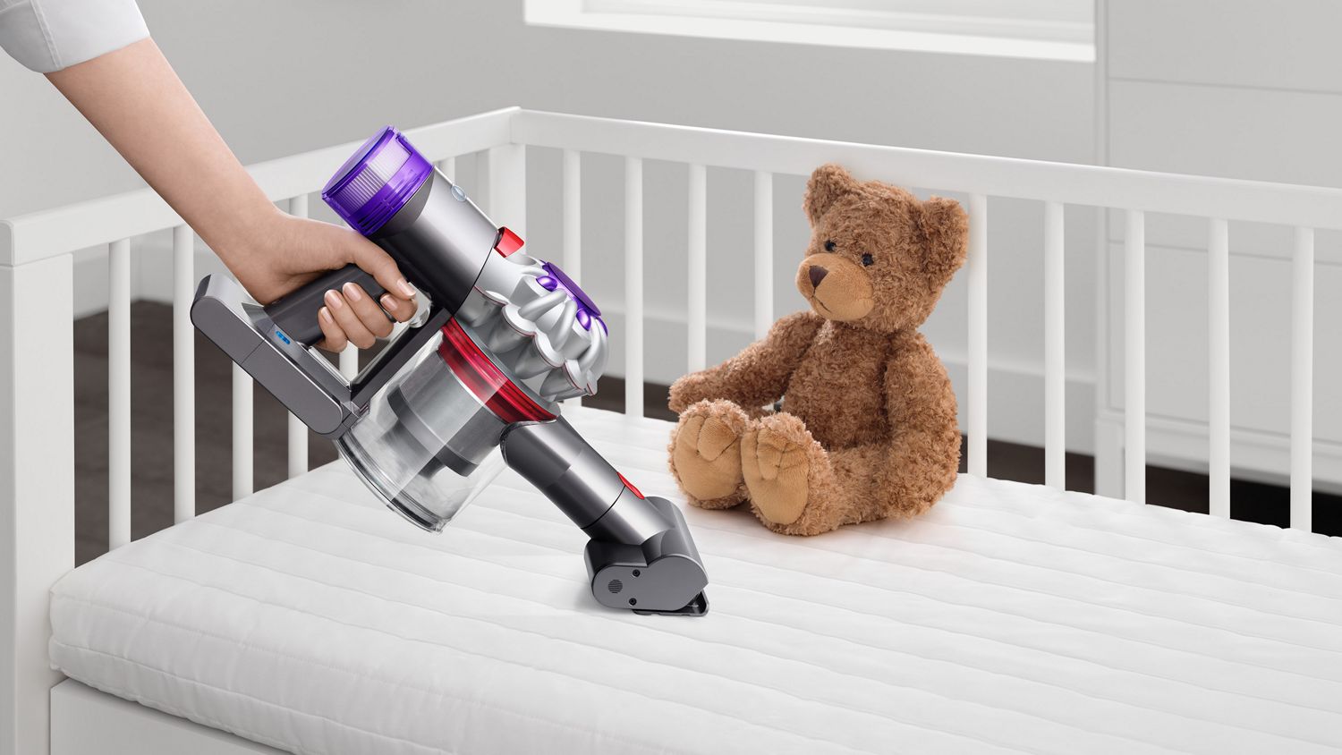 The Dyson Car+Boat handheld vacuum with the Mini motorised tool cleaning a crib mattress.