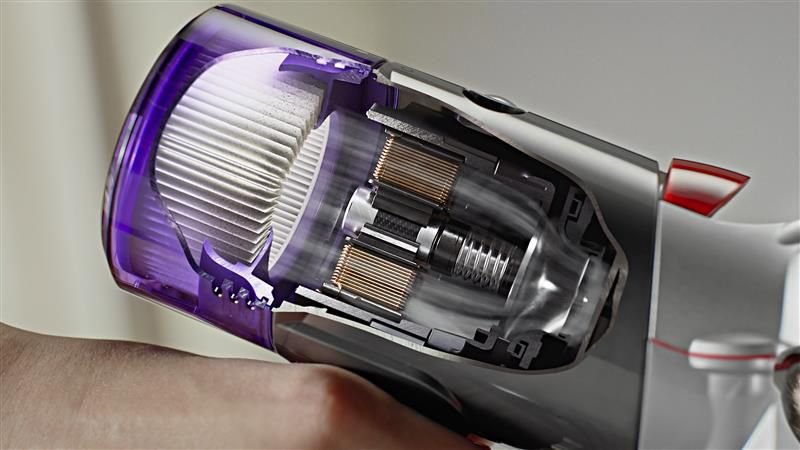A Dyson Car+Boat handheld vacuum is used to clean a kitchen.