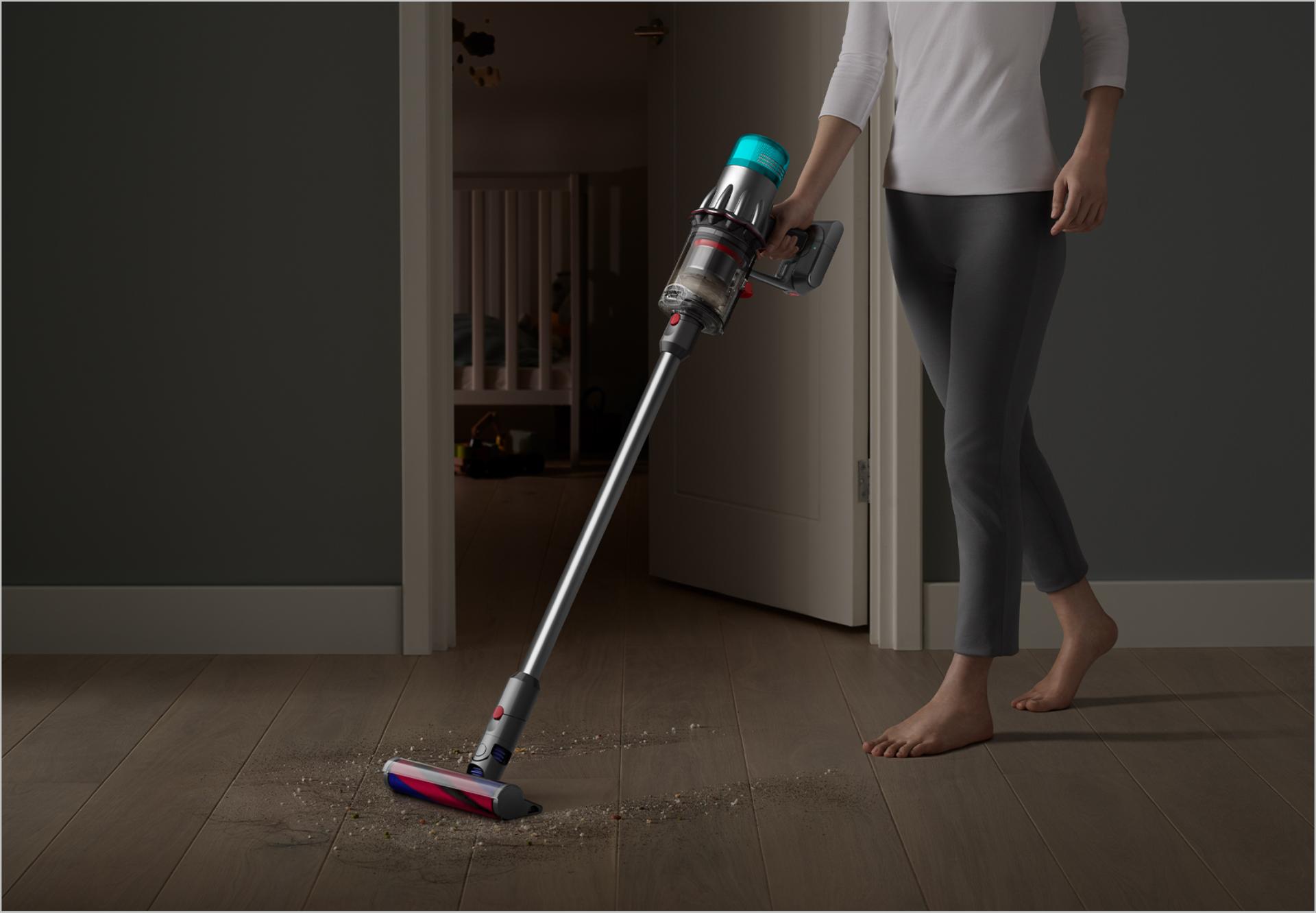 Dyson Digital Slim™ vacuum cleaning a hard floor by a bedroom door.